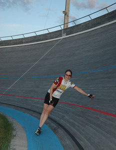 woman leaning against a velodrome track